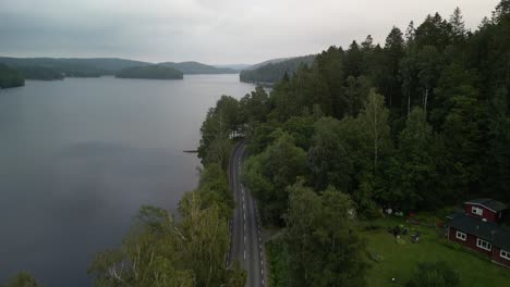 Aerial-of-lakeside-forested-road,-Sweden