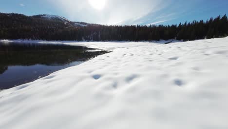 Un-Impresionante-Vuelo-FPV-Sobre-Las-Orillas-Del-Lago-Nevado-Palù,-Valmalenco,-Italia.