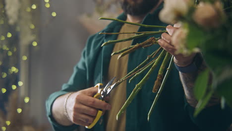 Männlicher-Professioneller-Florist-Schneidet-Stängel-Frischer-Blumen-Im-Blumenladen