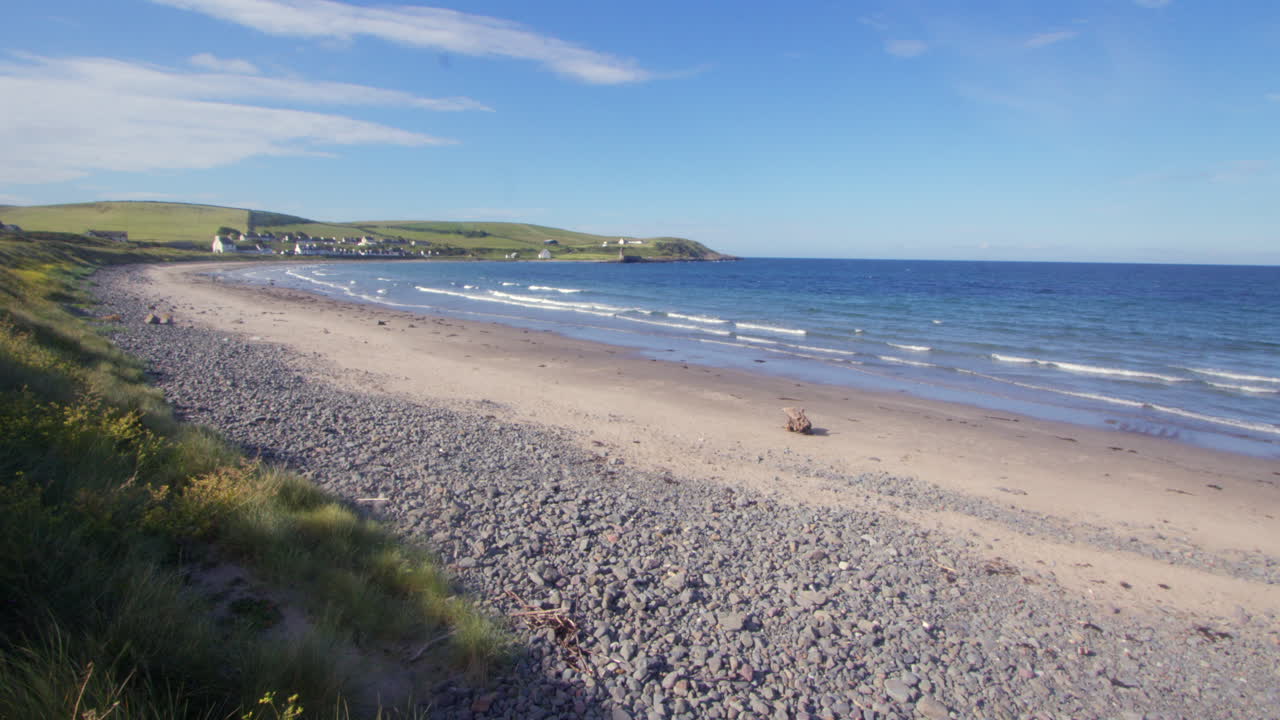 Extra wide shot of port Logan beach with port Logan in background