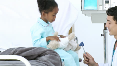 young doctor examining little girls reflex