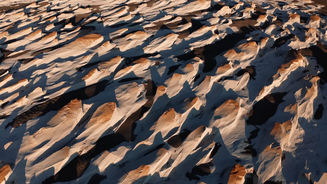 Primo piano di texture ondulate di roccia pomice che si estendono su un vasto suolo desertico vulcanico