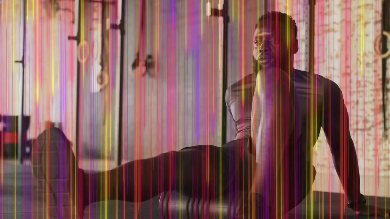 Uomo che fa rotolare la coscia destra su un foam roller, spostando i fianchi per iniziare il recupero, con artefatti che si sovrappongono ad anelli.