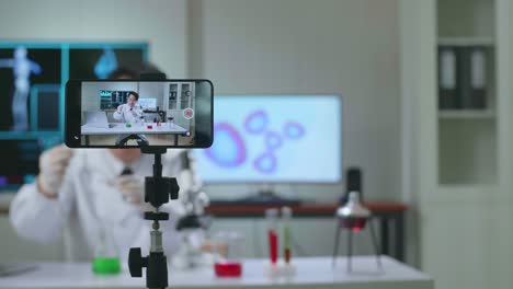 asian scientist man using smartphone recording video while researching in the laboratory