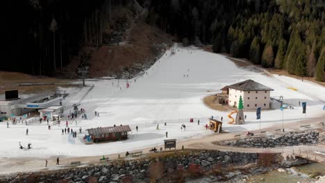 slow motion rotating aerial shot over a chair lift and children skiing at auronzo ski mountain in italy