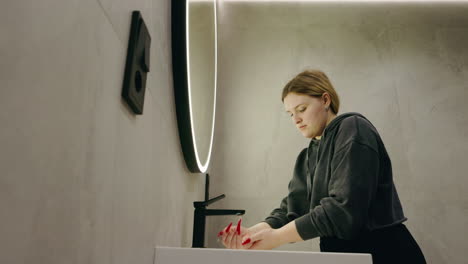 woman washing hands in a modern bathroom