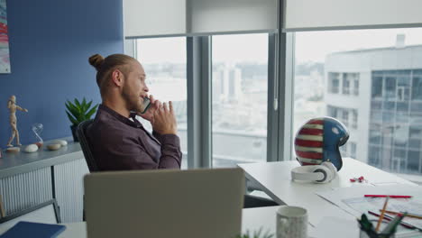 confident man gesturing mobile at desk closeup. designer consulting client