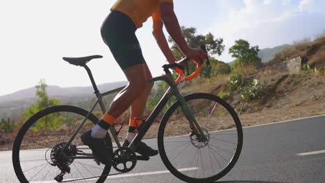 Un-Hombre-Toma-Su-Bicicleta-De-Carretera-Para-Hacer-Ejercicio-Al-Aire-Libre-En-Una-Carretera-Vacía-Por-La-Mañana.-La-Grabación-En-Cámara-Lenta-Subraya-El-Espíritu-De-Los-Deportes-Extremos.