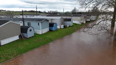 flooded riverbed approaching manufactured homes trailer park in rural usa