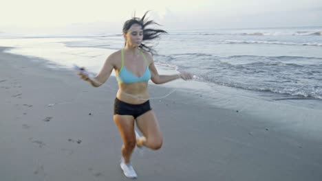 sporty woman running on beach