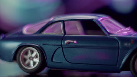 close-up of a blue toy car with purple and pink lighting