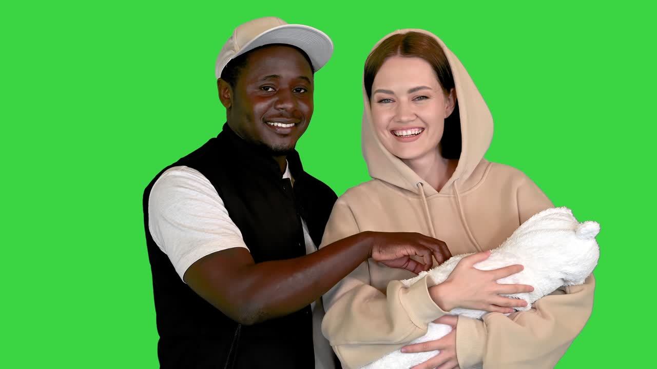 Happy African American man with his Caucasian wife and newborn baby on a Green Screen, Chroma Key