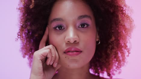 Biracial-woman-with-dark-curly-hair-in-pink-light,-slow-motion