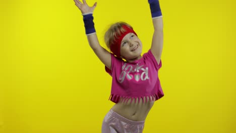 una pequeña y enérgica chica caucásica en ropa deportiva rosa haciendo un baile de fitness, bailarina de aeróbico moderno