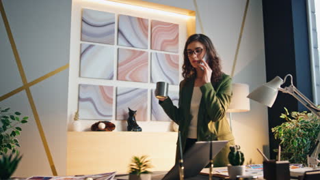 woman boss talking telephone in office with coffee cup. manager drinking calling