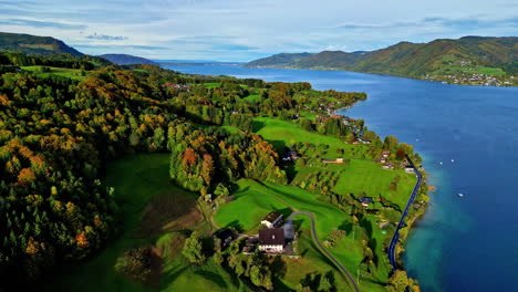 farms and fields along the shore of attersee lake, austria - pullback aerial