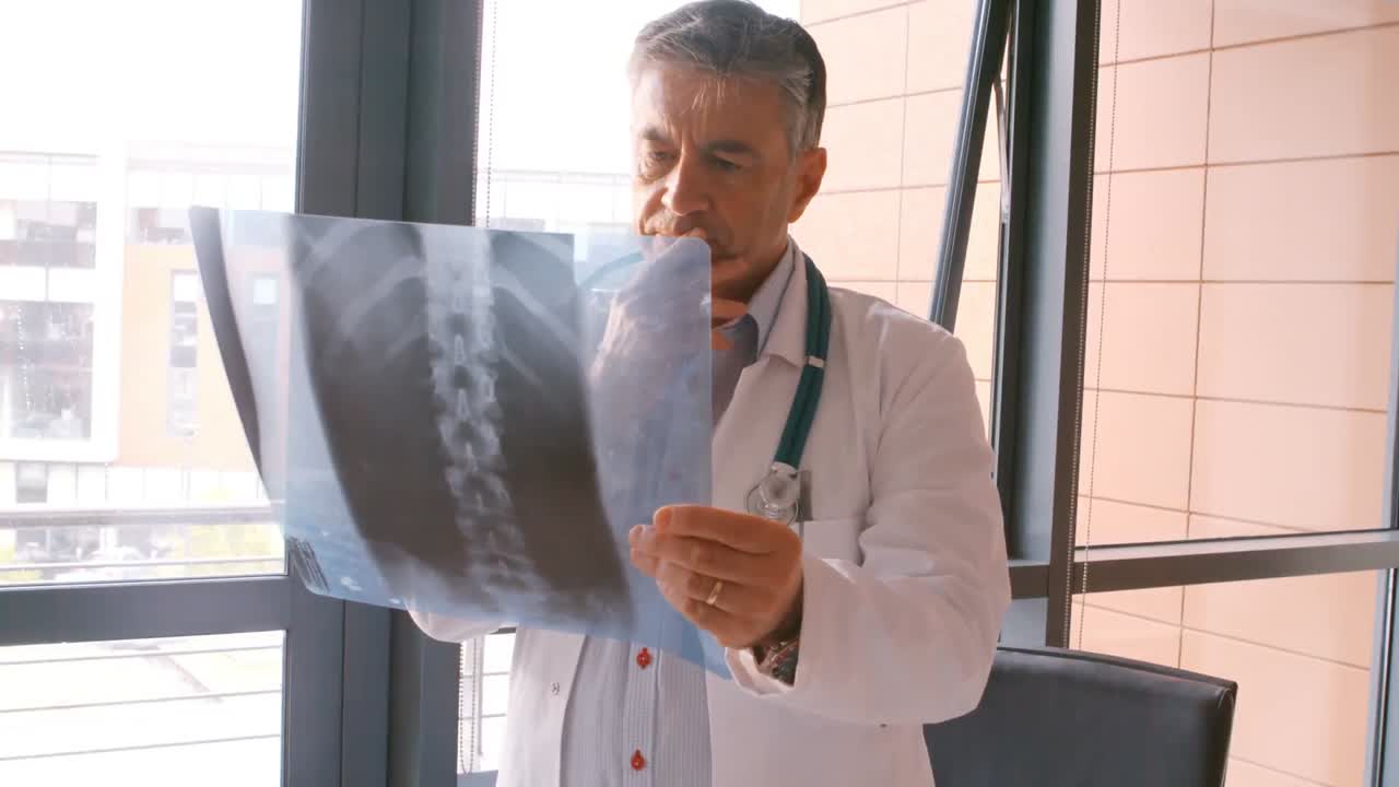 el médico chequeando un informe de rayos x