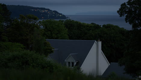 partes de una casa moderna en el bosque, residencia de nueva construcción rodeada de árboles, mar oscuro con niebla en el fondo, el anochecer