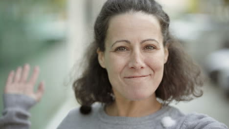 una hermosa morena de mediana edad sonriente hablando a la cámara.