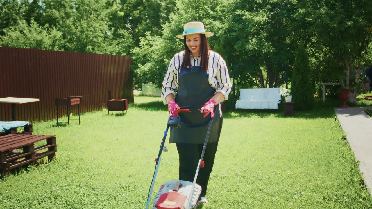 Woman mowing the lawn in a garden