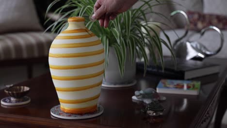 a female hand depositing a coin into a money clay jar