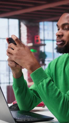 vertical video man at home using smartphone to compose social media posts