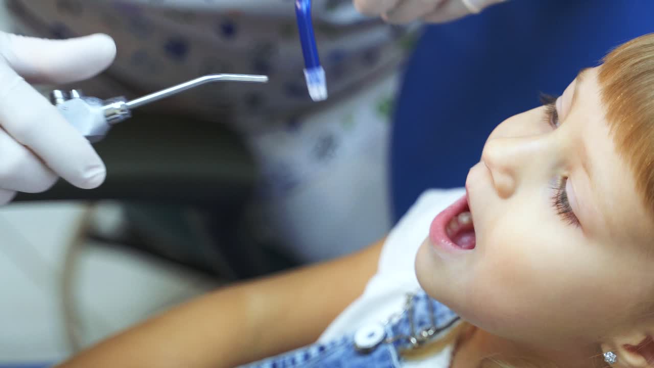 The doctor checks the teeth of a little girl. Little girl brushing teeth at the dental clinic