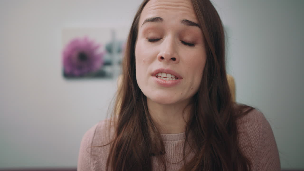 una mujer de negocios enojada jura hablando por skype en la oficina de casa.