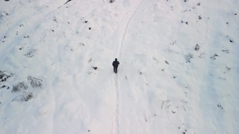 無人機拍攝一個人沿著雪道行走