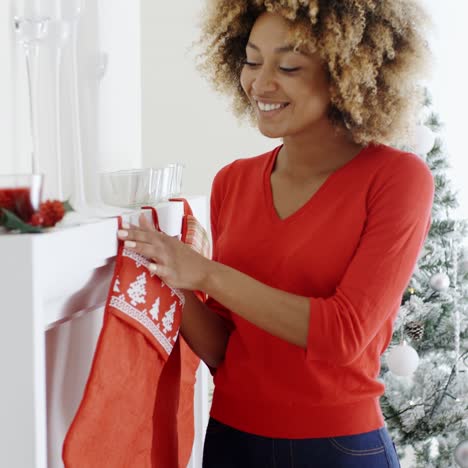 Glückliche-Junge-Frau,-Die-Weihnachtsstrümpfe-Hängt