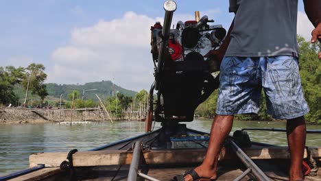 a person steering a traditional boat engine