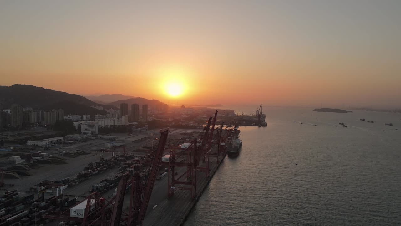 해가 지는 공중 영상은 위쪽에서 보이는 의 크레인과 컨테이너를 보여줍니다.