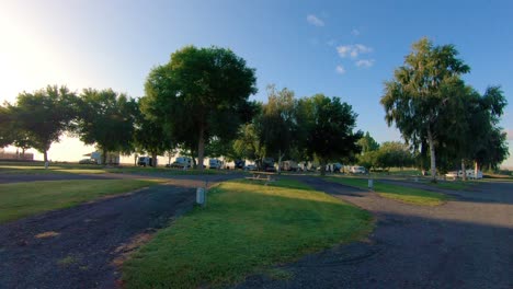 pan of an rv resort with asphalt roads and a few guests in the late afternoon