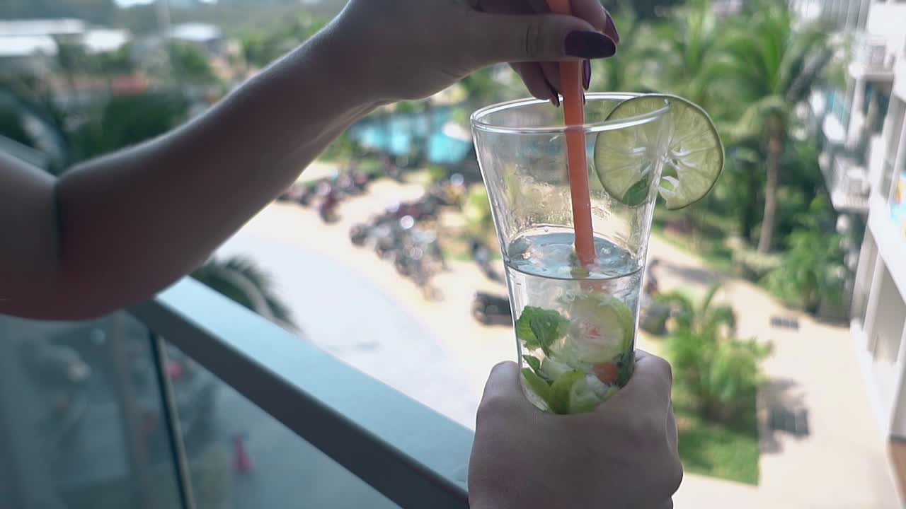 여자 는 휴가 에 있는 초록색 손바닥 에 대항 하여 테라스 에 서 있다