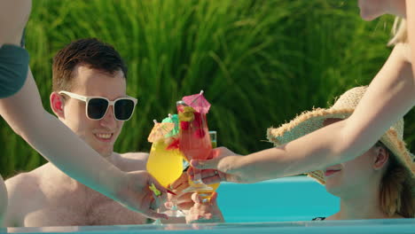 friends toasting drinks at pool party