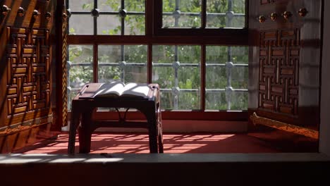 a quran being read in a traditional islamic interior