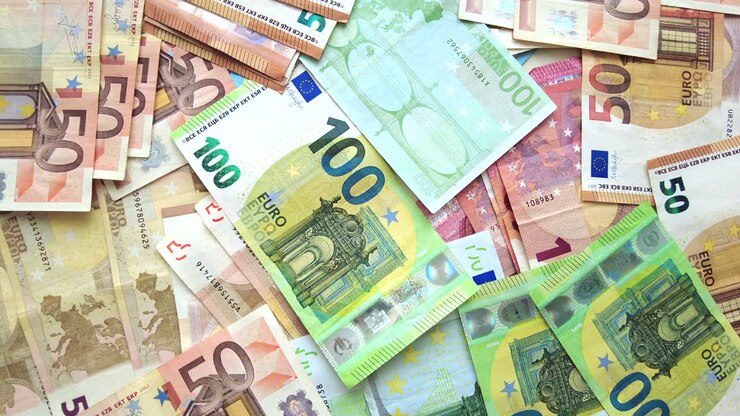 Nahaufnahme von mehreren Fünfzig- und Hundert-Euro-Scheinen, die auf einer Oberfläche verstreut sind