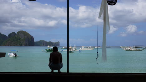 Hombre-Descansando-Frente-A-La-Magnífica-Vista-Al-Mar-Del-Puerto-Deportivo-En-Un-Día-Soleado