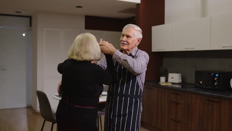 Senior-couple-in-love-dancing.-Romantic-evening-supper-with-wine-and-candles-celebrating-anniversary