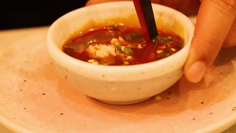 hand stirring sauce in a small bowl