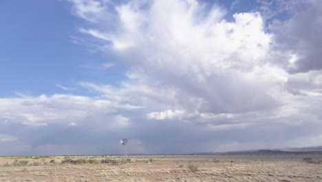 drone dando vueltas alrededor de un molino de viento mientras mira hacia arriba al épico cielo azul