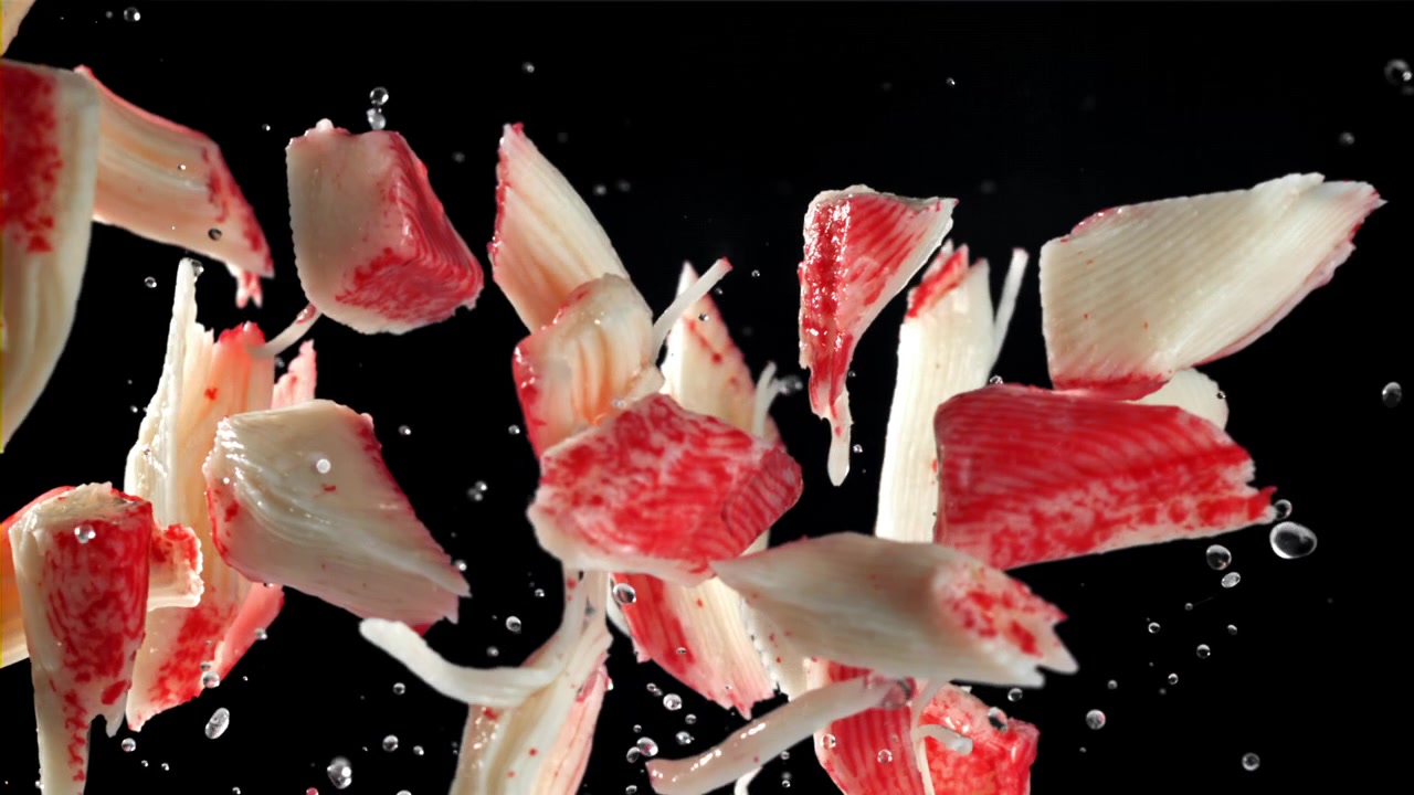 Fresh Imitation Crab Meat Pieces Falling and Splashing in Slow Motion
