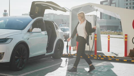 mujer bailando en la estación de carga de coches eléctricos