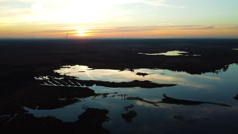 golden sunset and swampland bellow, aerial drone view