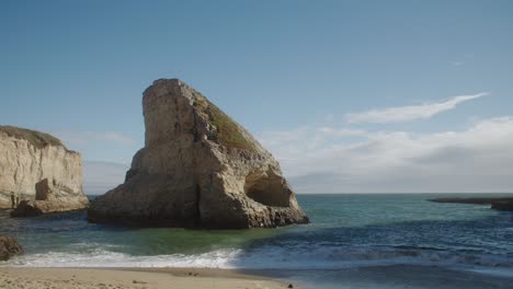 Toma-De-Establecimiento-De-La-Cala-De-Aleta-De-Tiburón-Desde-La-Costa-De-La-Playa-Con-Olas-Rompiendo-Suavemente