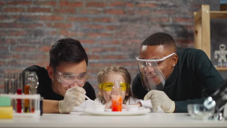 chemist pours catalyst girl with teacher looks at reaction