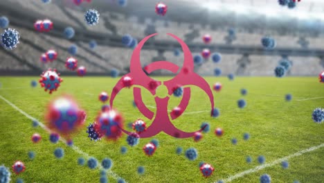 biohazard symbol and covid-19 cells against empty sports stadium