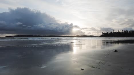 A-slow-motion-video-of-waves-crashing-on-the-beach-with-a-cloudy-sunset-in-the-background