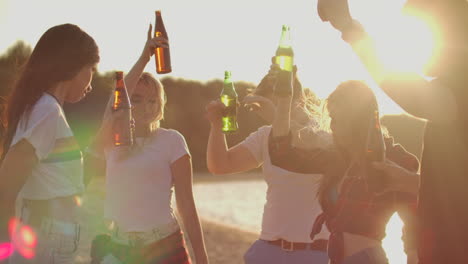 Die-Studenten-Genießen-Eine-Sommerparty-Im-Freien-Am-Strand-Mit-Bier.-Sie-Tanzen-Am-Flussufer-Und-Verbringen-Eine-Tolle-Zeit-In-Der-Natur.