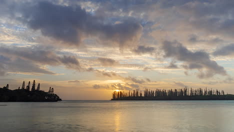 low clouds blow over silhouetted isle of pines